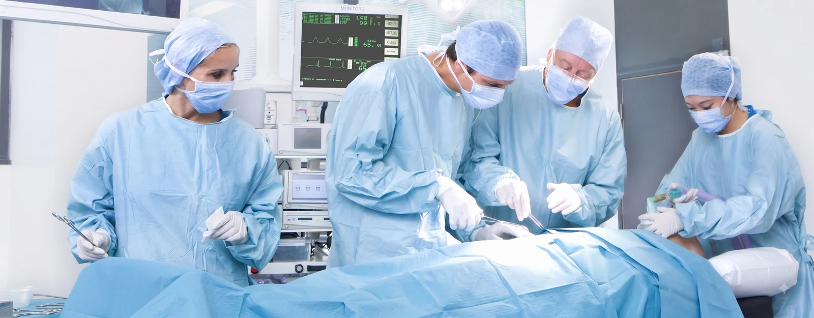 Surgical team using infection control gowns and drapes in an operating room